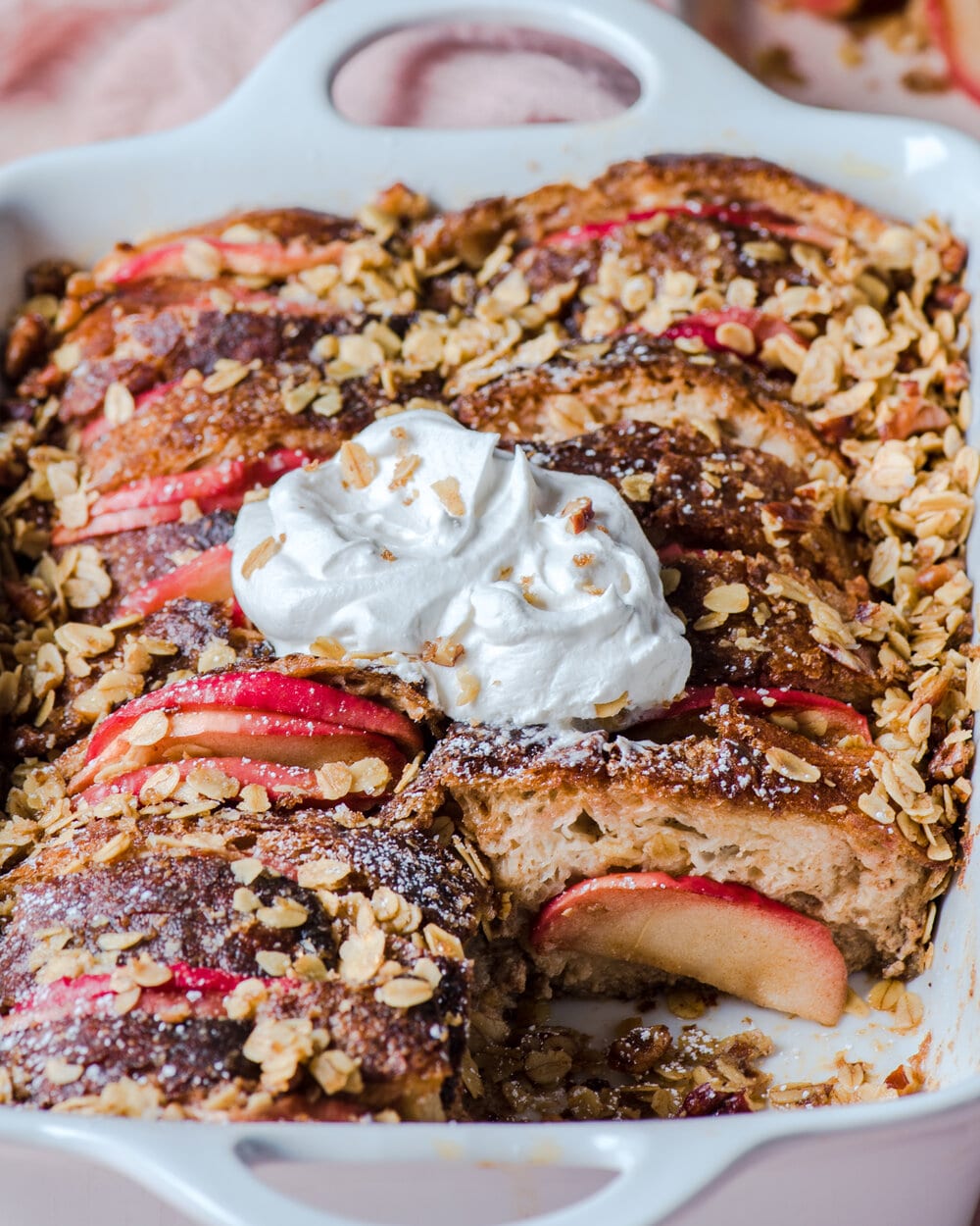 French toast casserole in casserole dish with a slice taken from it.