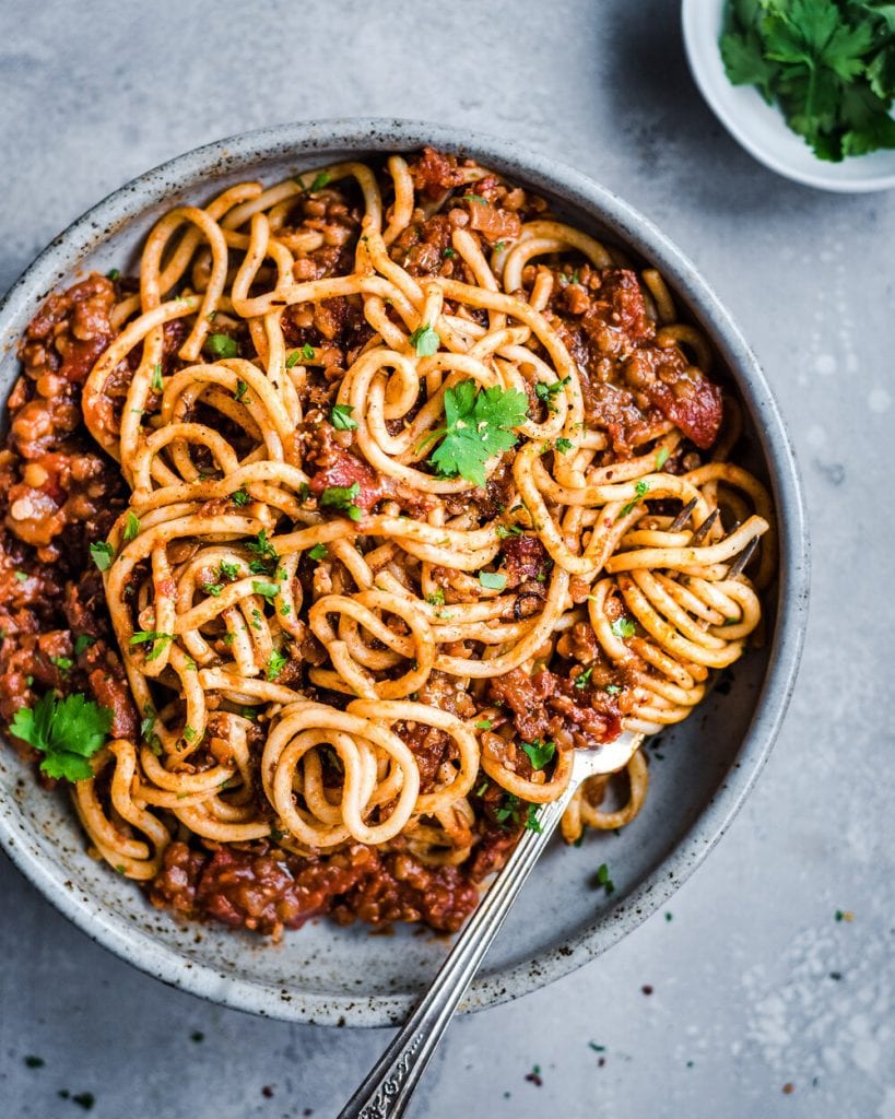 red lentil bolognese twirled with fork with parsley