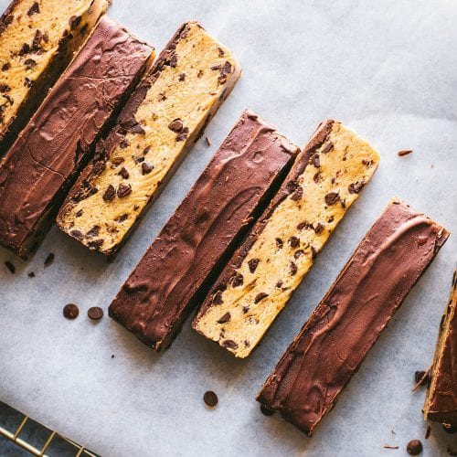 chocolate chip cookie dough bars arranged in a line on parchment paper