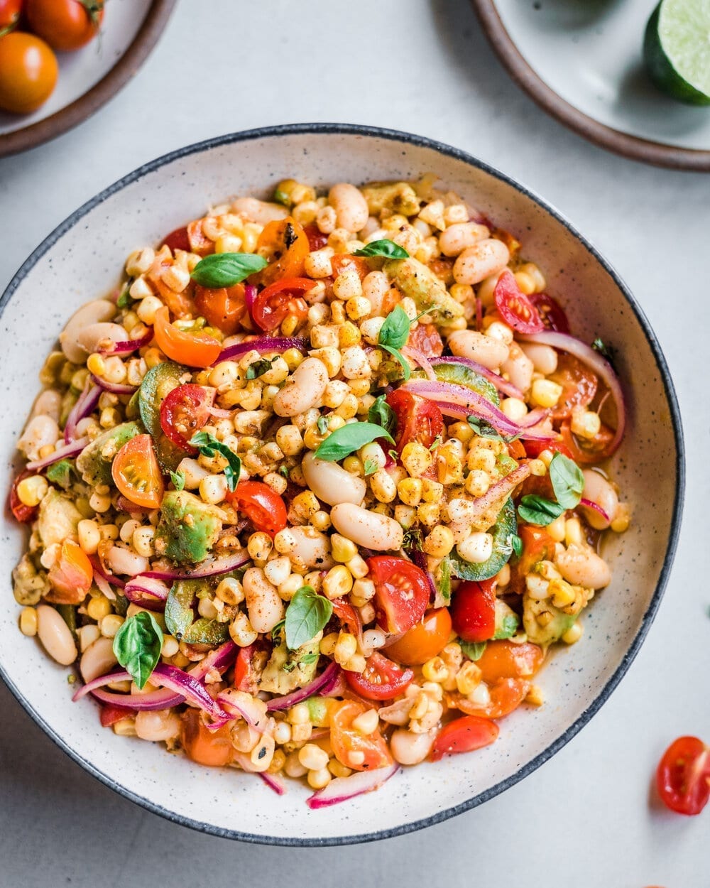 Charred corn salad with white beans in a bowl on a table.