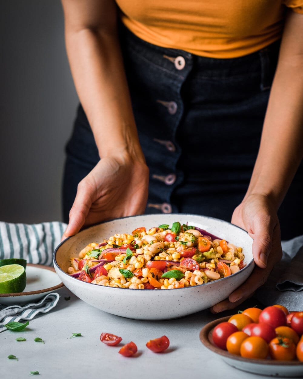 woman holding bowl of corn salad