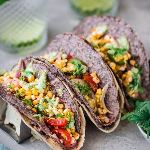 3 black bean and corn double wrapped tacos in taco holders