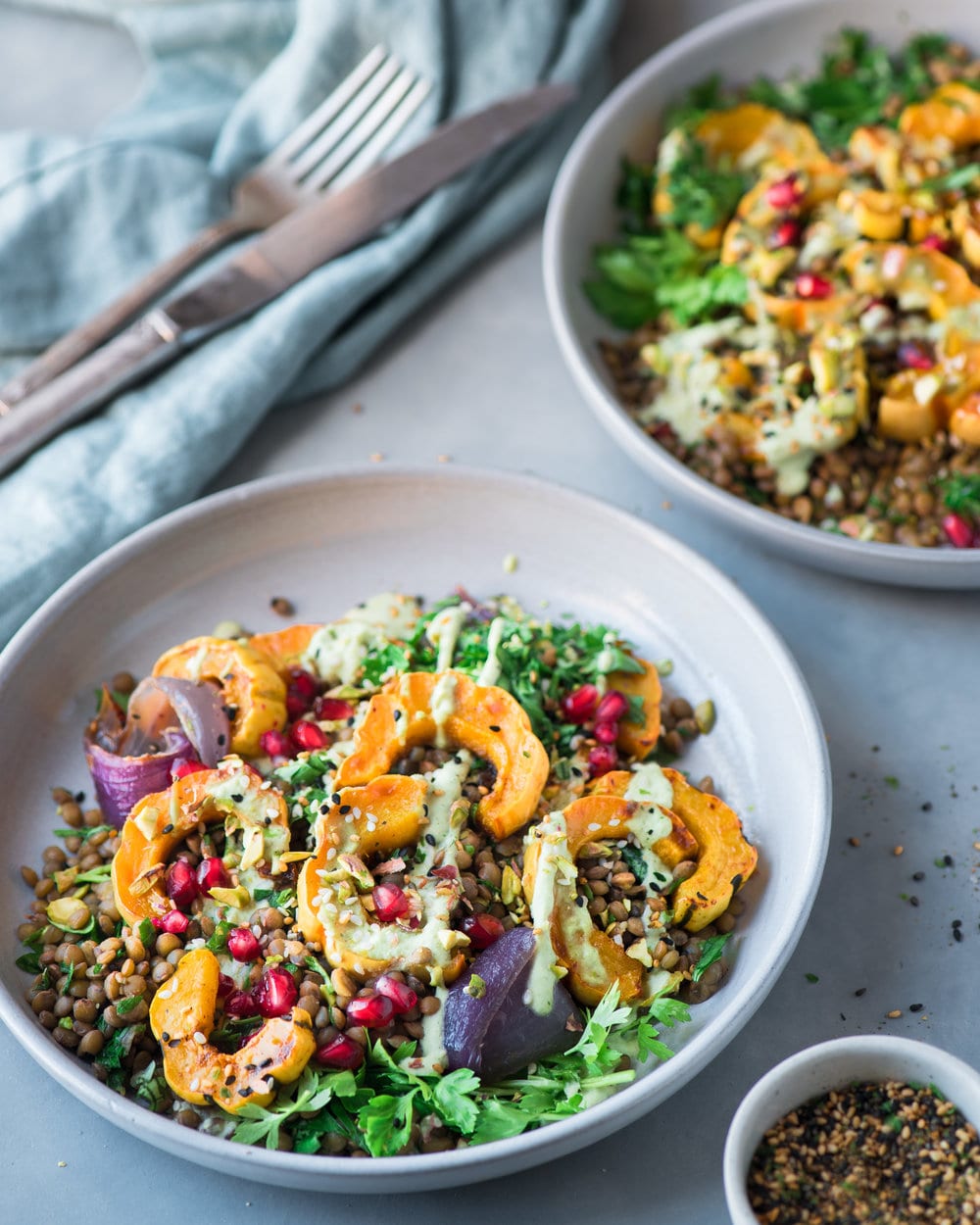 Two large bowls filled with lentil salad on a grey table.