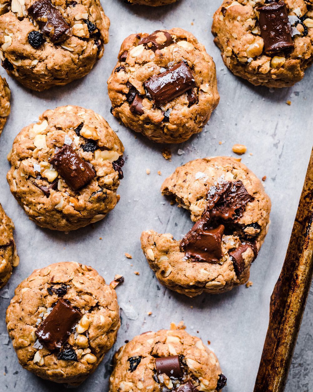 Six cookies on a piece of parchment paper on a baking sheet.