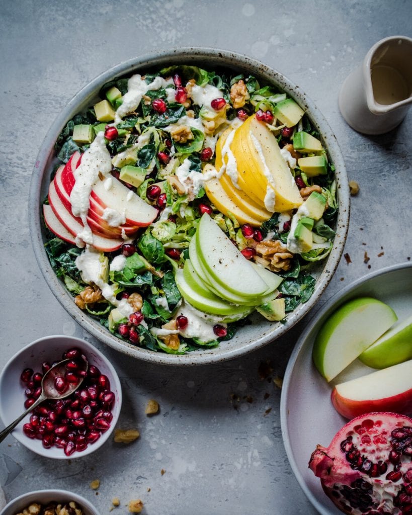 kale salad with sliced apples and pomegranates