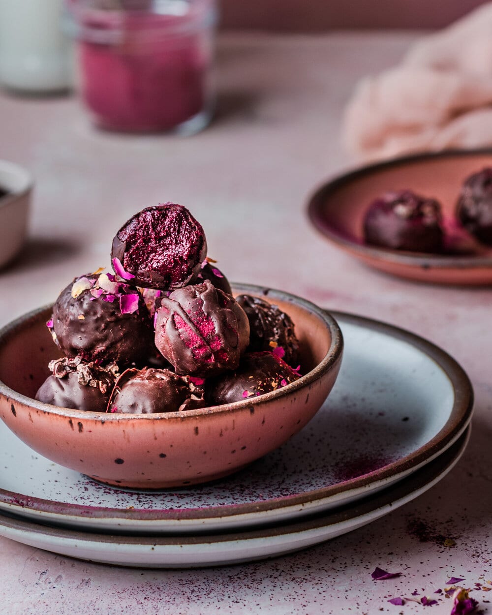 Red bowl of fudgy beet truffles on a blue plate.