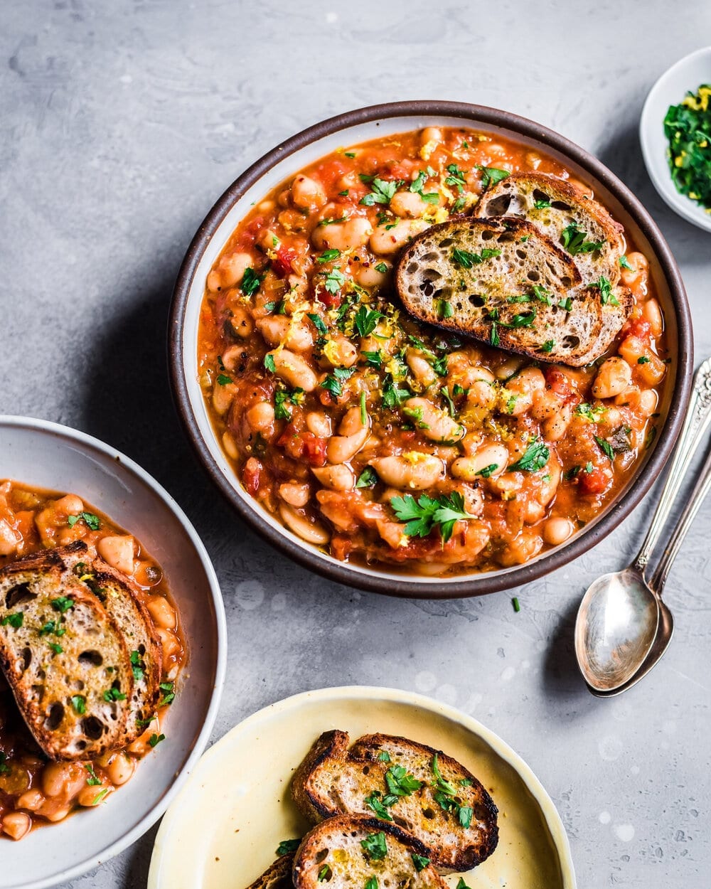 bowl of white bean tomato stew with plate of toasted bread