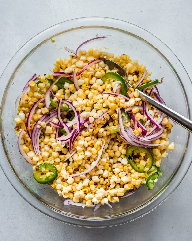 corn mixed with onions in a bowl