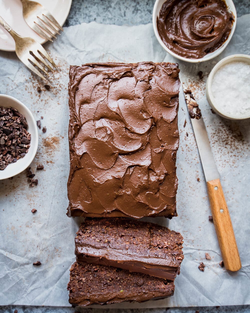 Overhead view of nutella cake and knife on parchment paper.