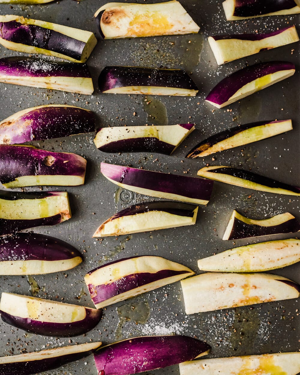 eggplant wedges tossed with olive oil, salt and pepper on a sheet pan. 