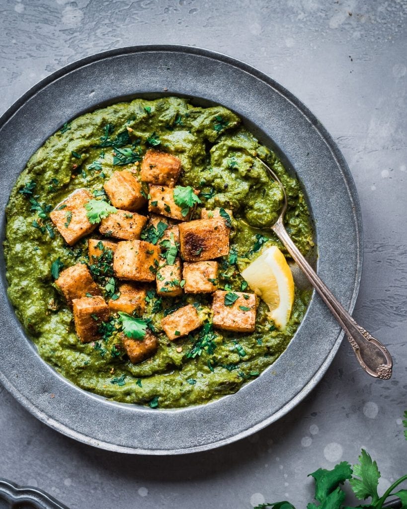 baked tofu resting on top of spinach curry