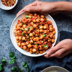 bowl of Indian chana masala framed by hands