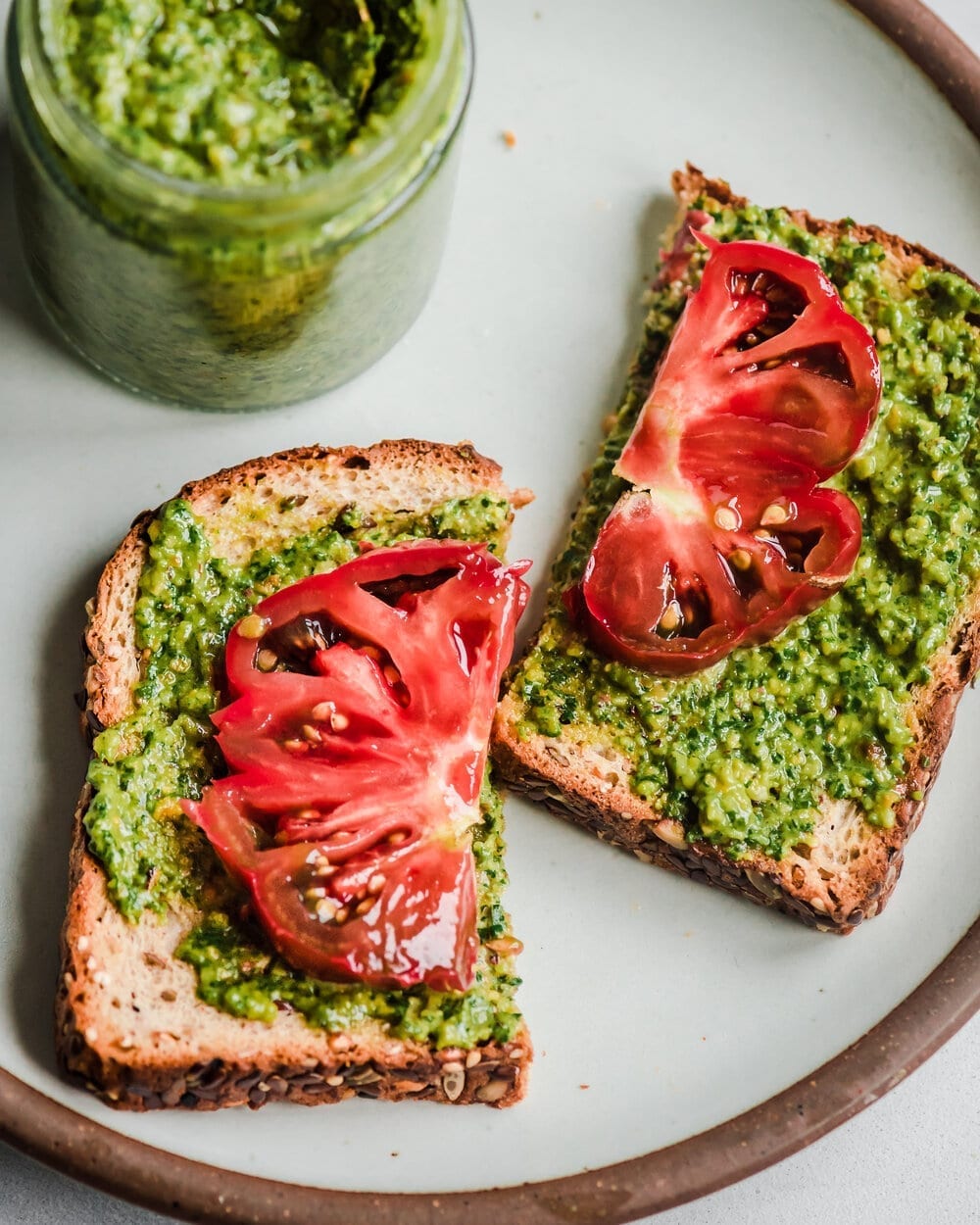vegan basil pesto on sliced toast with heirloom tomatoes