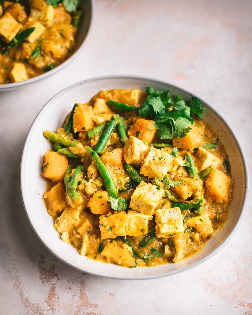 Curry di zucca vegano con tofu. Curry indiano di zucca con tofu, latte di cocco e fagiolini.