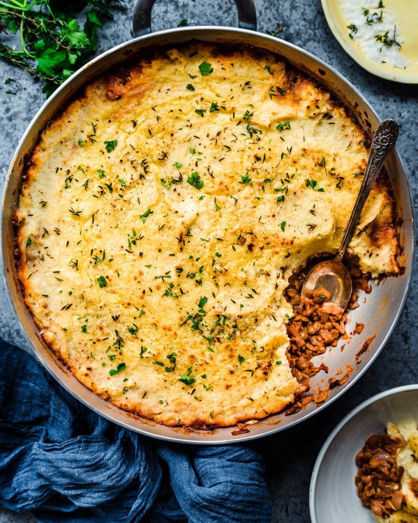 baked vegan lentil shepherd's pie in skillet with spoon dug in