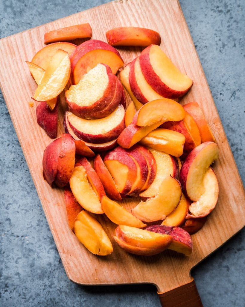 sliced peaches on wooden cutting board