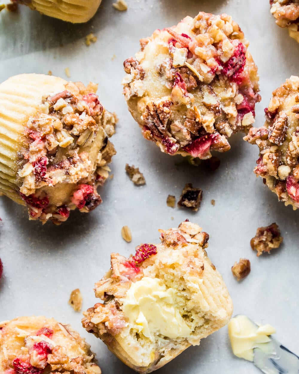 Close up overhead photo of a few finished muffins on a sheet of parchment paper.