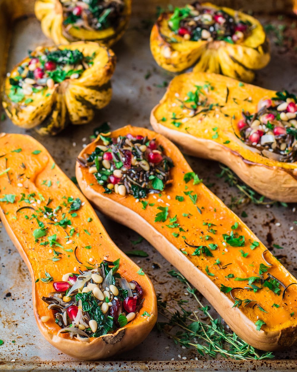 Side view of six stuffed squash halves on a baking tray.