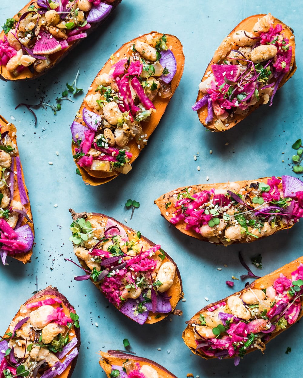 Nine stuffed sweet potato halves on a blue table.