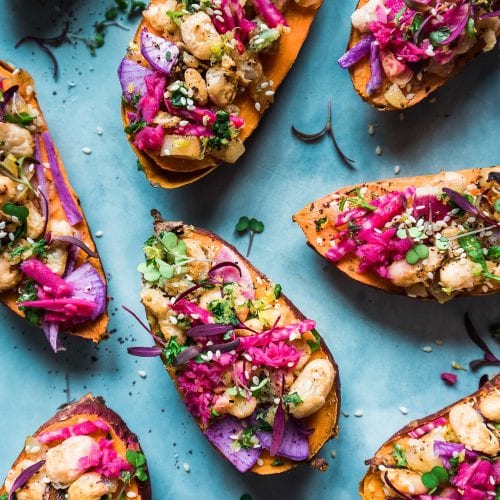 Nine tuffed sweet potatoes on blue table.