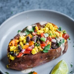 vegan southwestern tofu scramble with black beans and salsa stuffed into a sweet potato