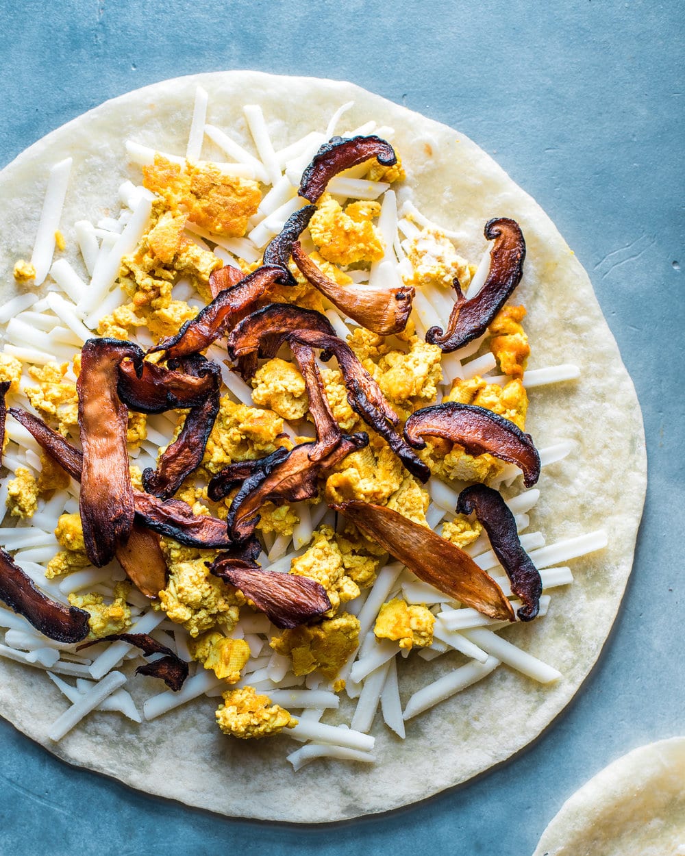 Uncooked breakfast quesadilla before being folded in half.