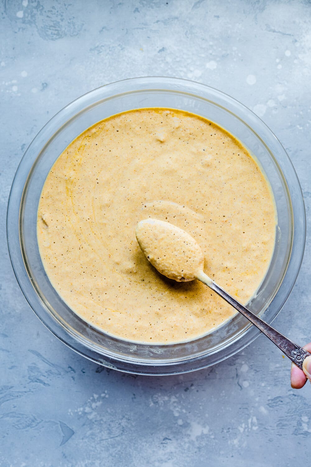 Pancake batter in a bowl with a spoon.