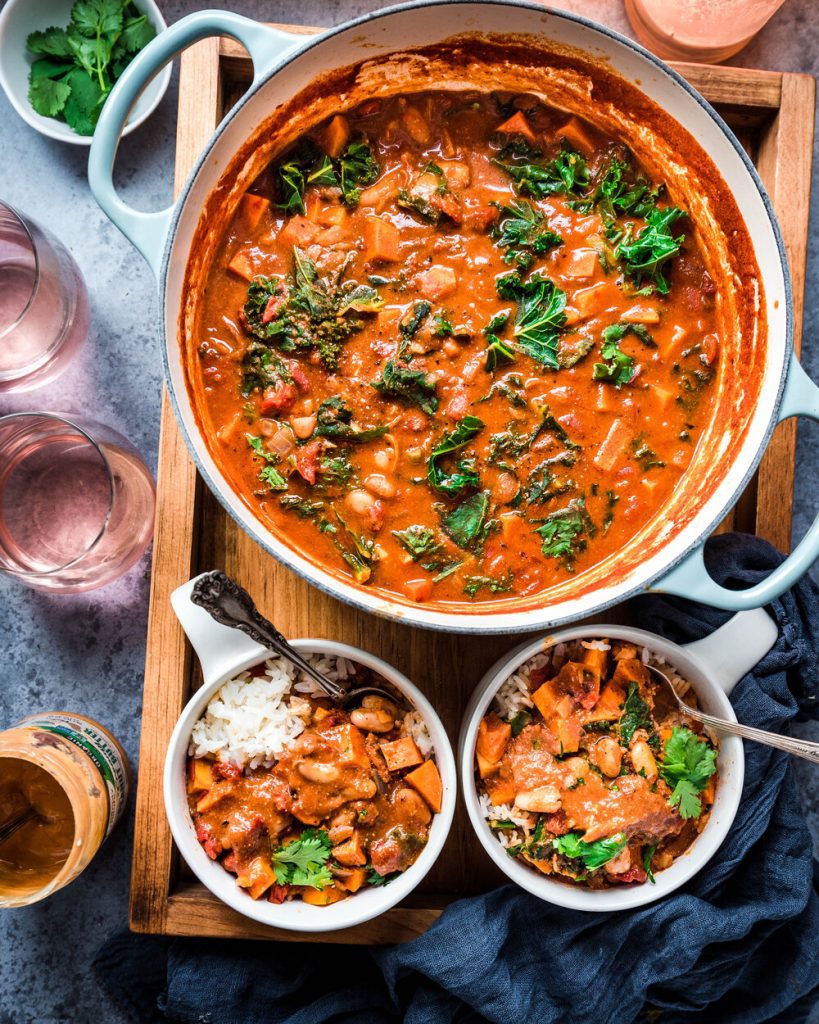 vegan west african peanut stew in dutch oven with two small bowls of peanut stew