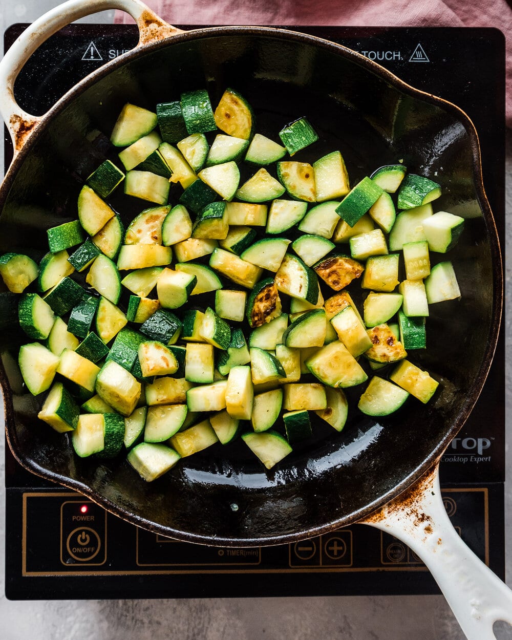 Zucchini browning in a cast iron skilelt