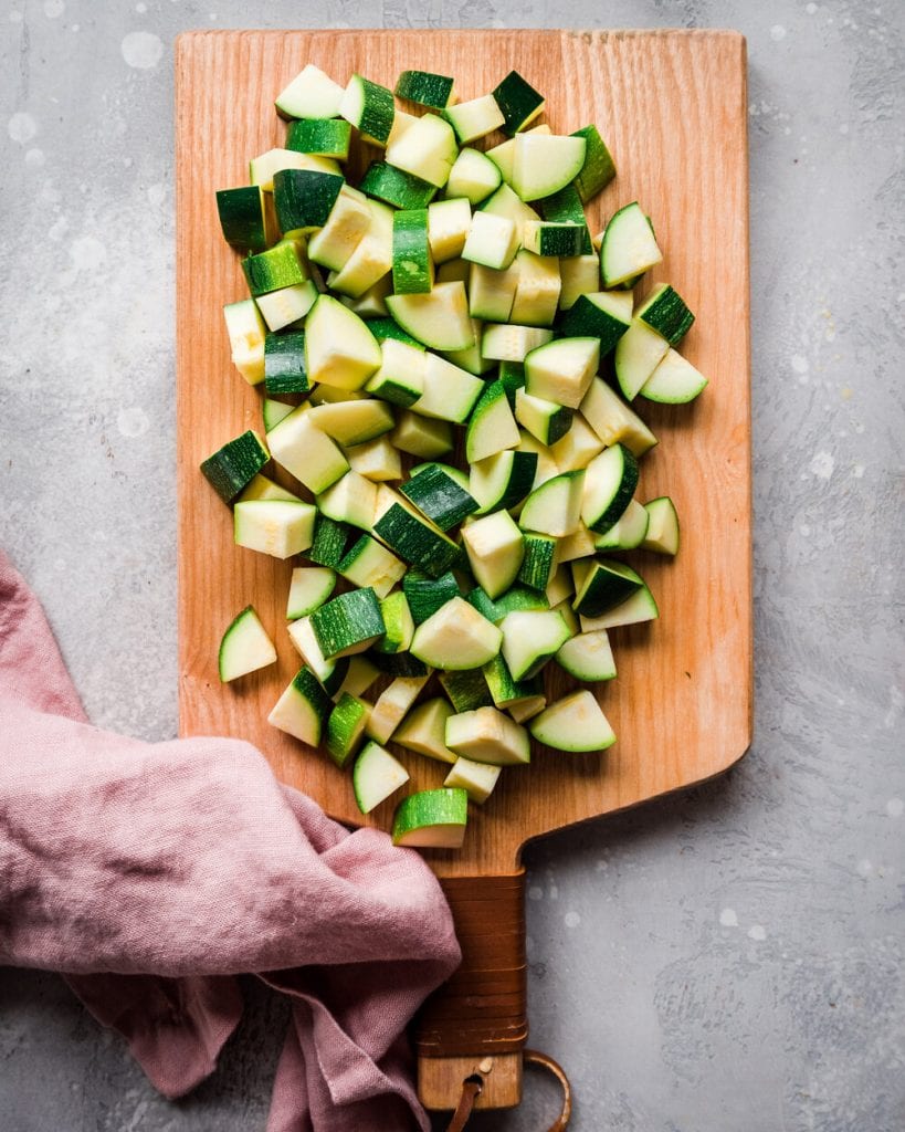 Chopped zucchini on a wooden cutting board