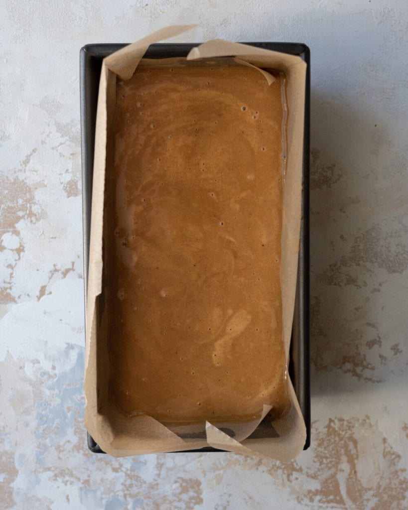 cake batter in lined loaf pan