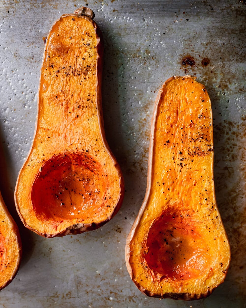 roasted butternut squash halves on baking tray