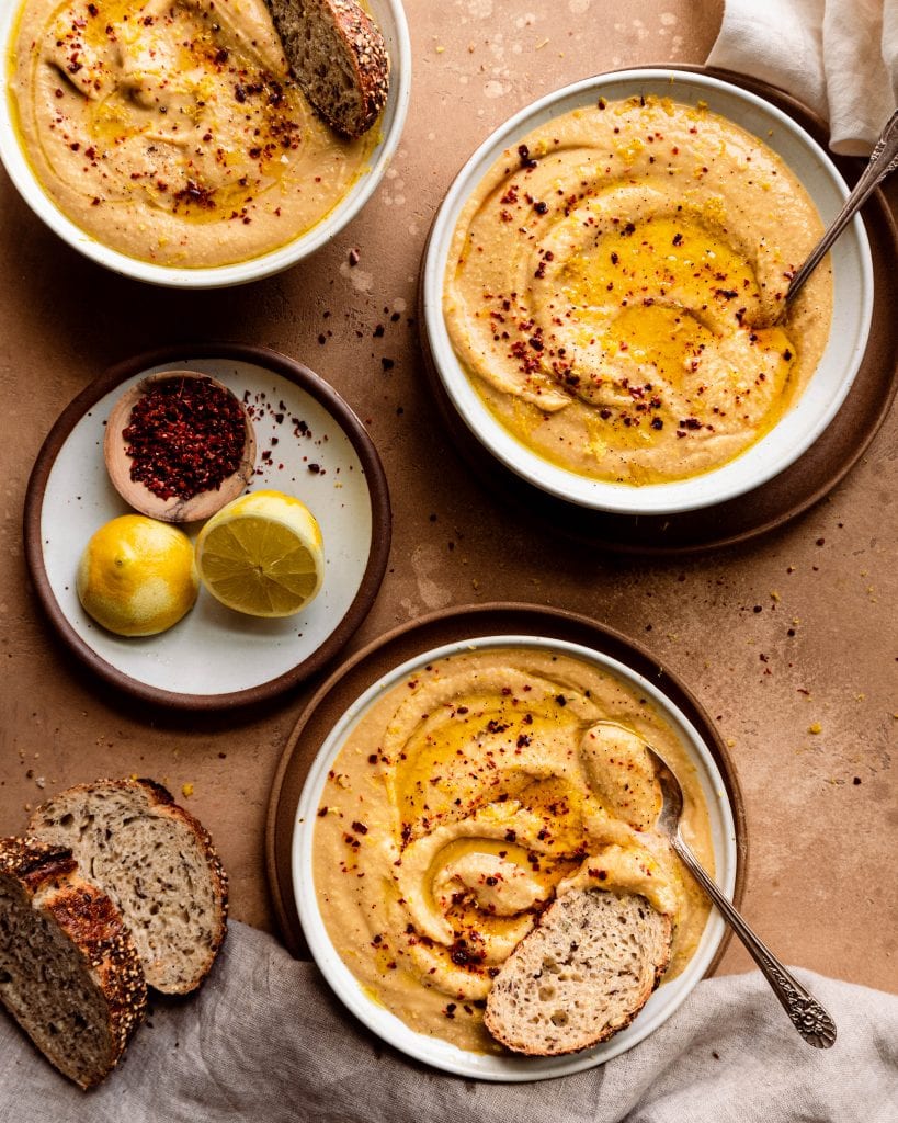 three bowls of creamy cauliflower soup with bread