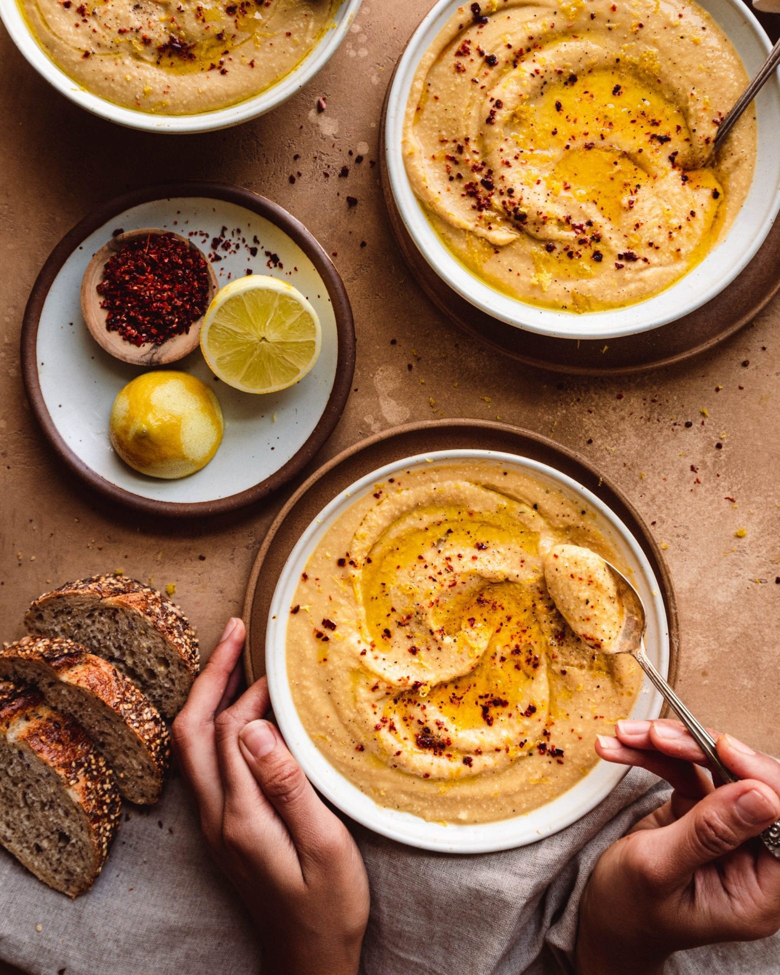 hands about to pick up a spoon of creamy soup