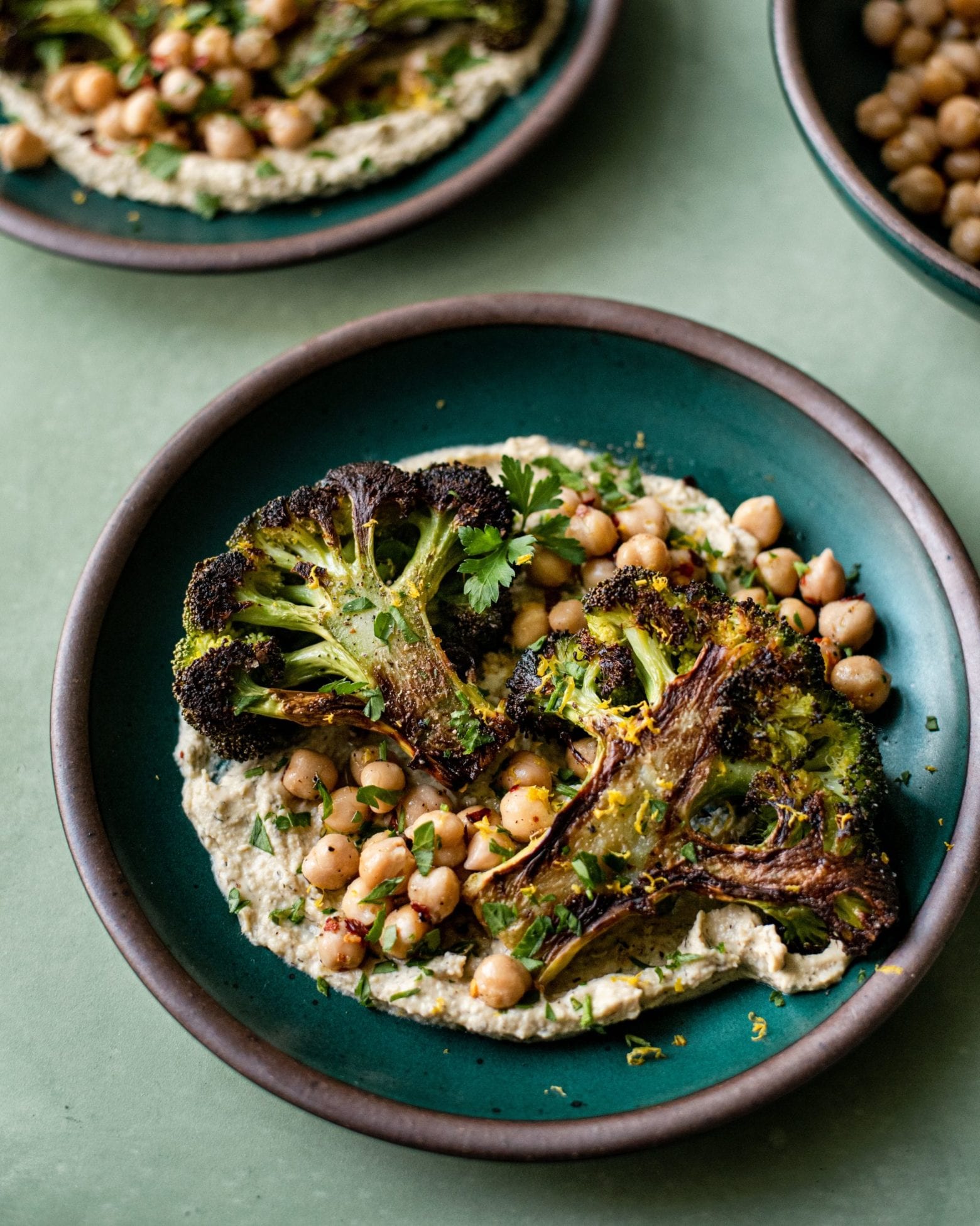 Veganuary Tips. roasted broccoli steak with chickpeas on top of hummus