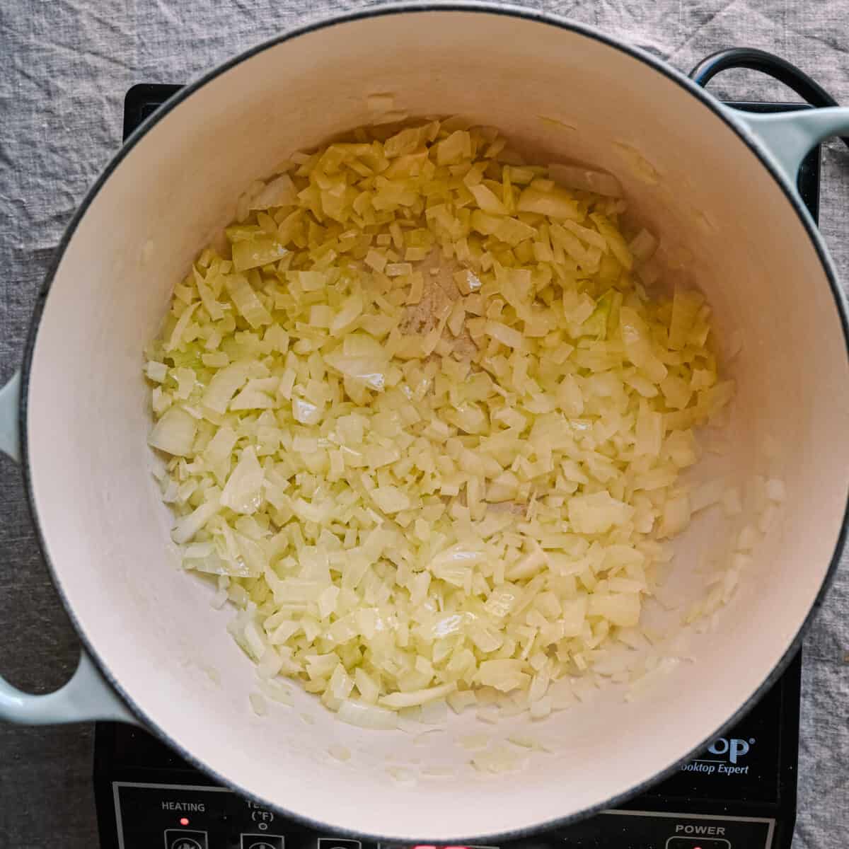 onions sauteing in olive oil in dutch oven
