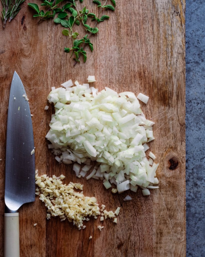 chopped garlic and onions on cutting board