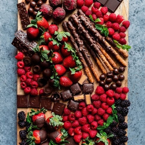 dessert board with berries, chocolates, and snacks