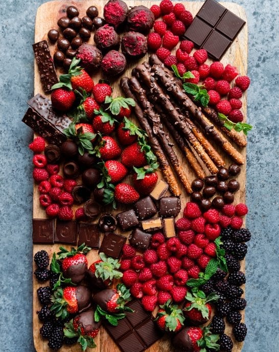dessert board with berries, chocolates, and snacks