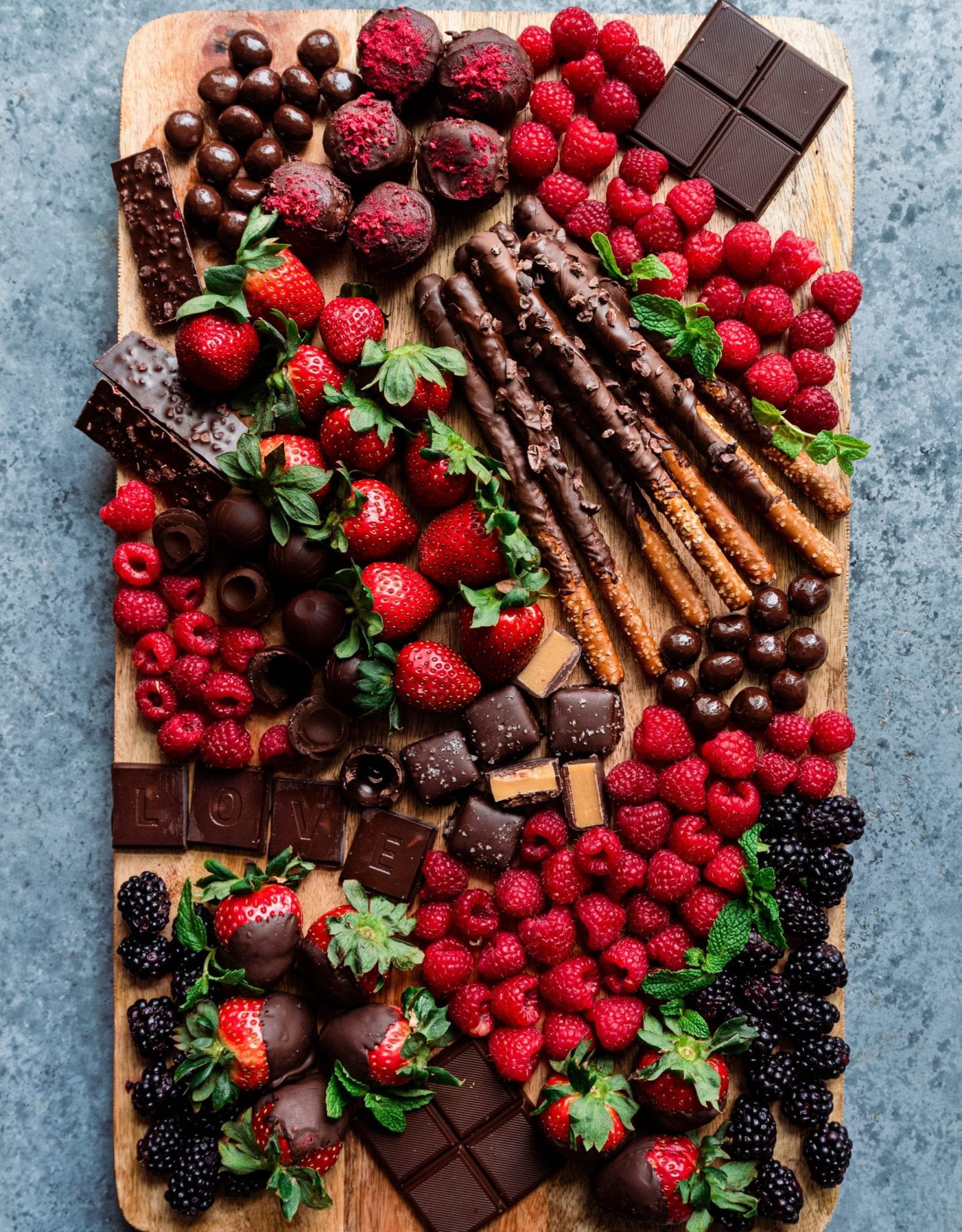 Different chocolate and berry ingredients on a large wooden board.