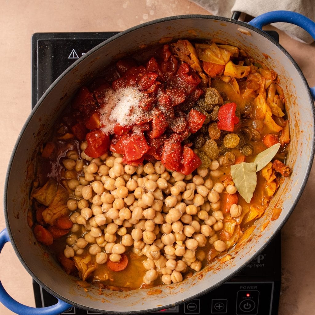 chickpeas and tomatoes in a stew in a dutch oven