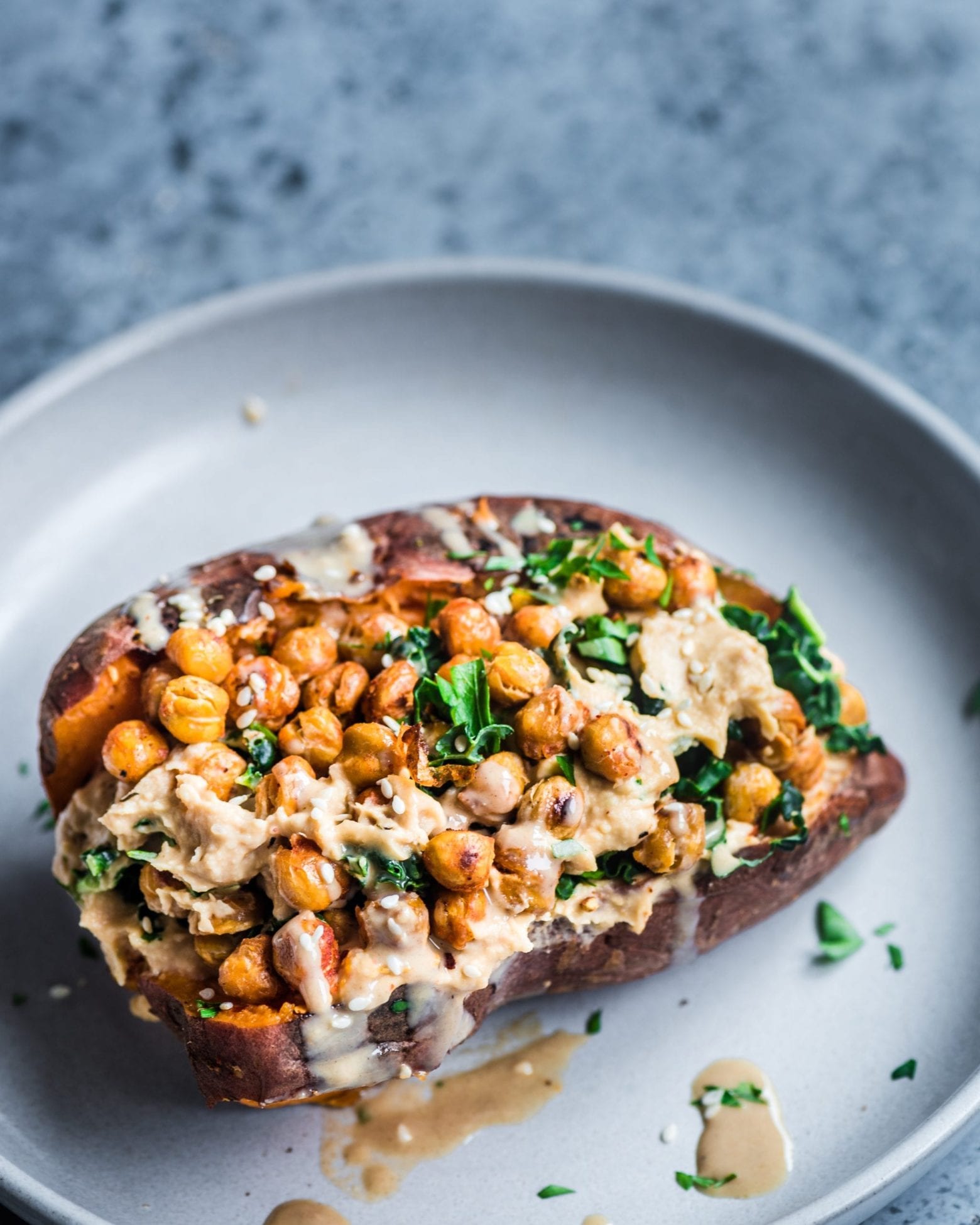 stuffed baked sweet potato with crispy chickpeas, hummus, and kale