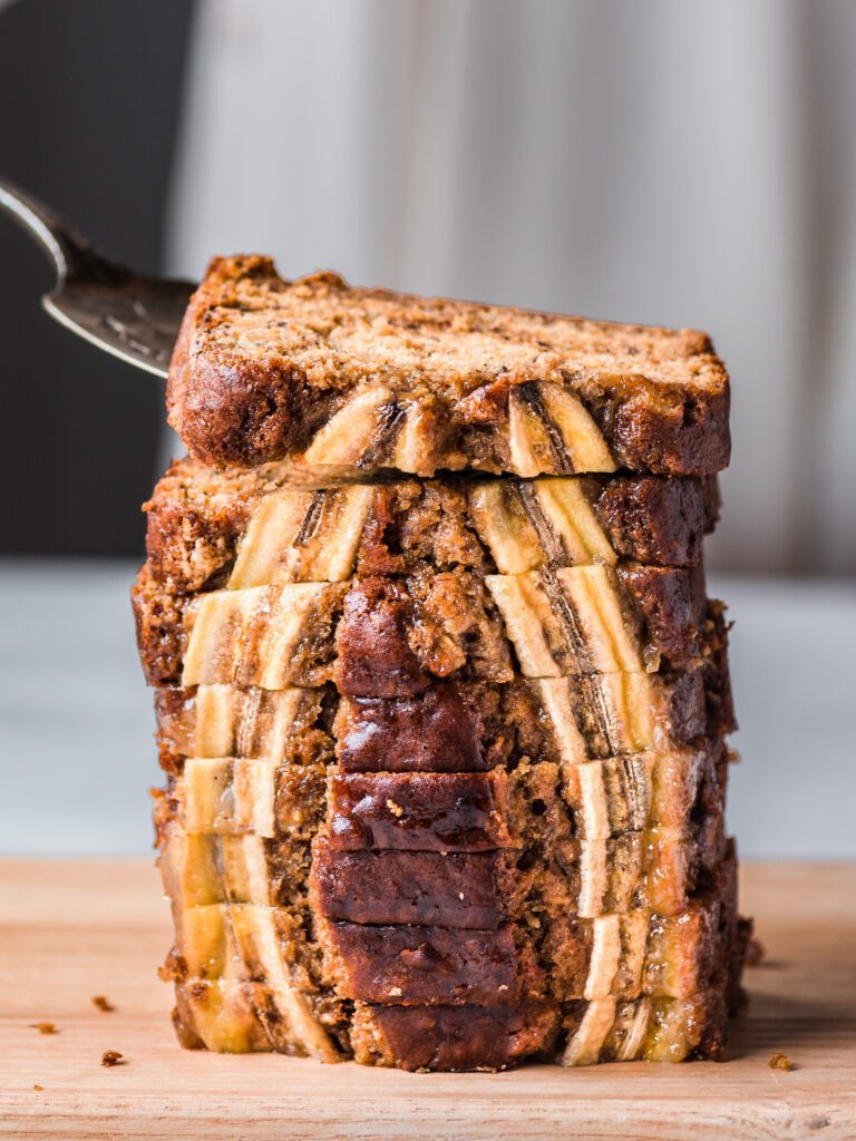 woman lifting slice of banana bread