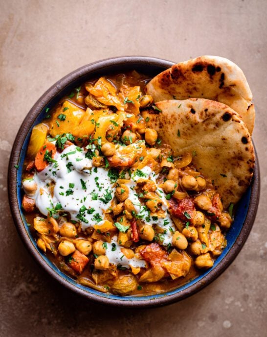 chickpea stew in a bowl with warm naan bread