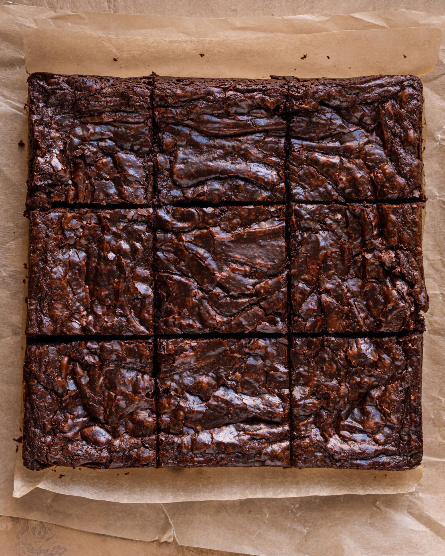 flatlay of sliced vegan brownies with shiny top on parchment paper