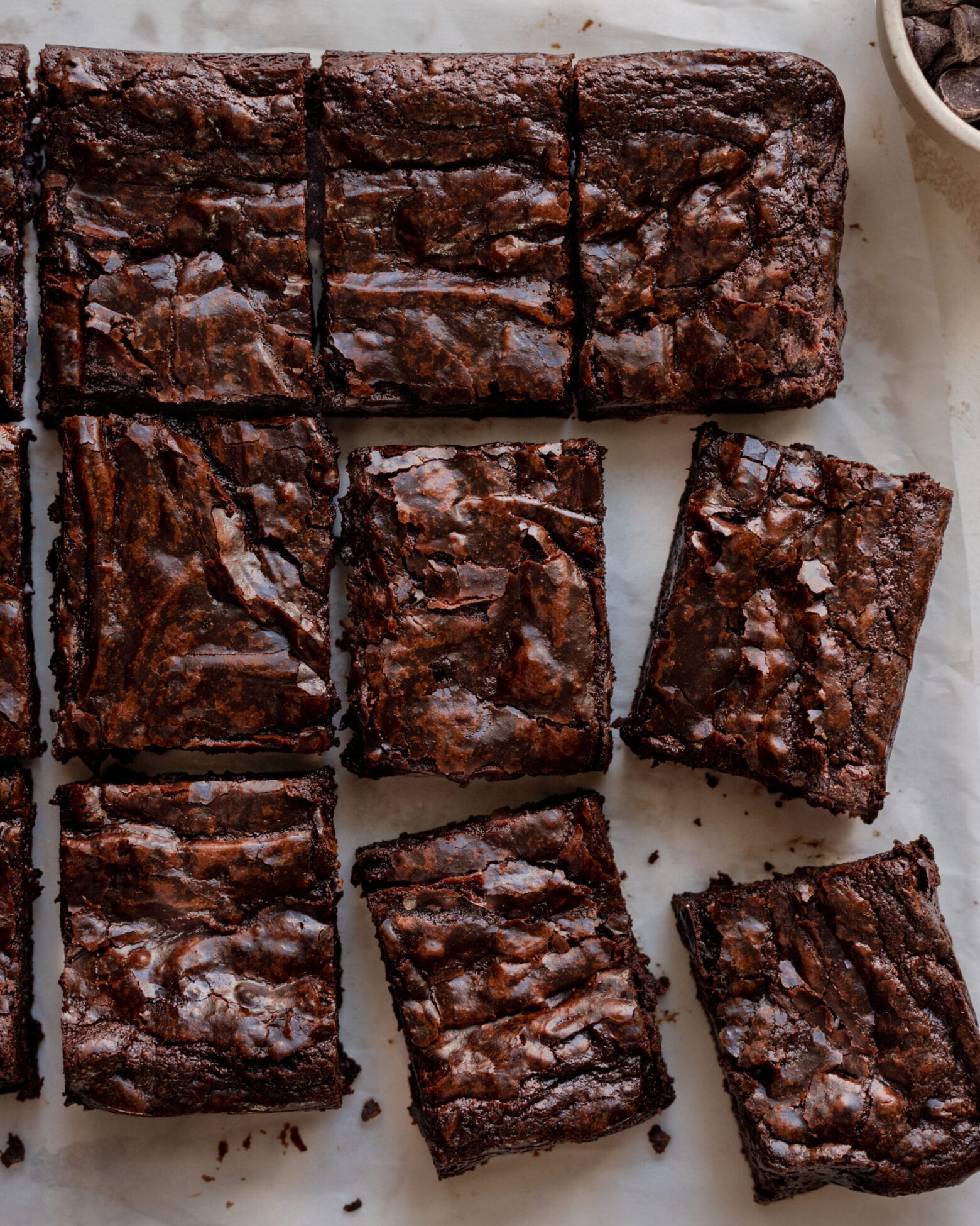 the best vegan brownies with a shiny top sitting on parchment paper
