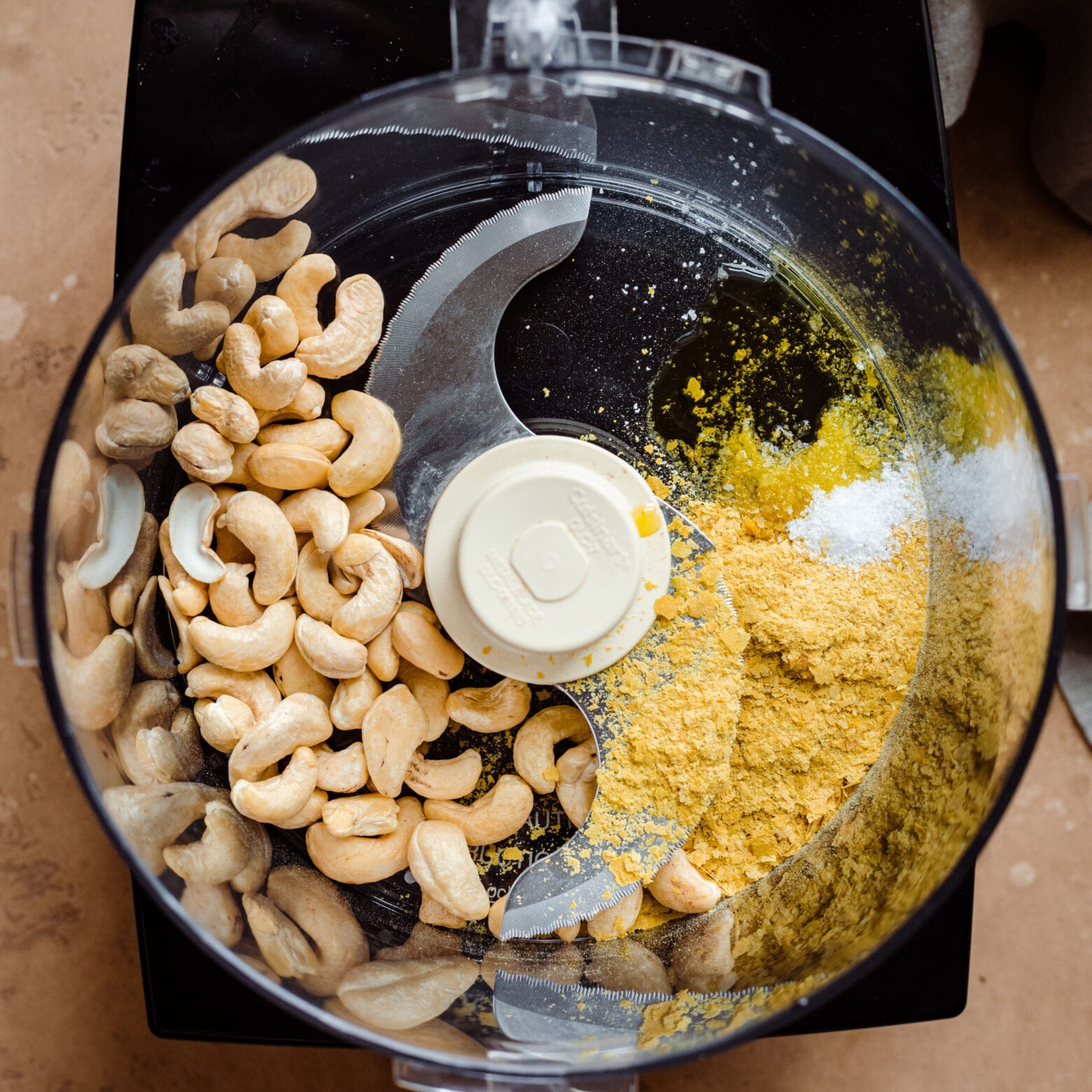 cashews and nutritional yeast in food processor for cashew parmesan.