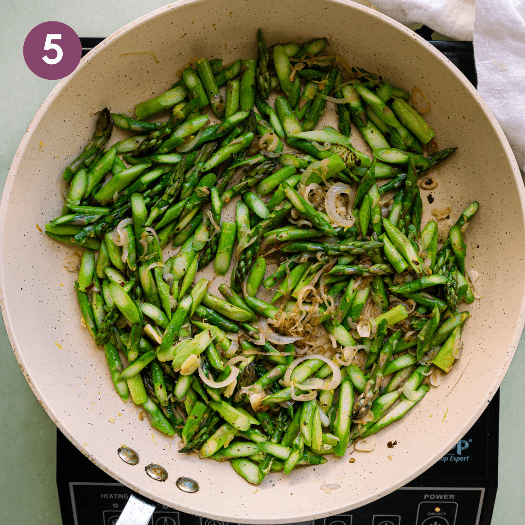 sauteed asparagus and shallots in a frying pan.