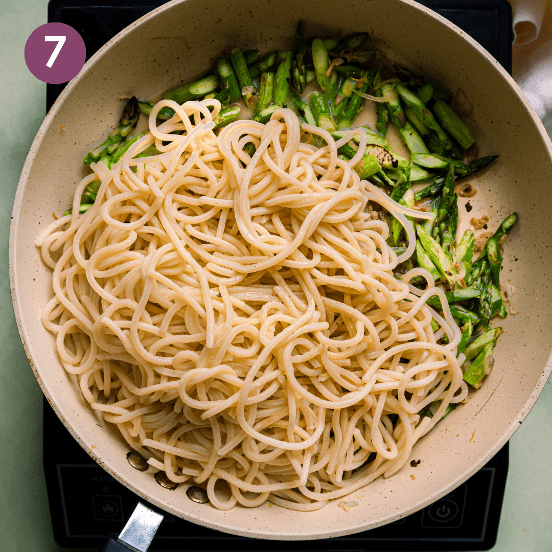 spaghetti and asparagus in saute pan.