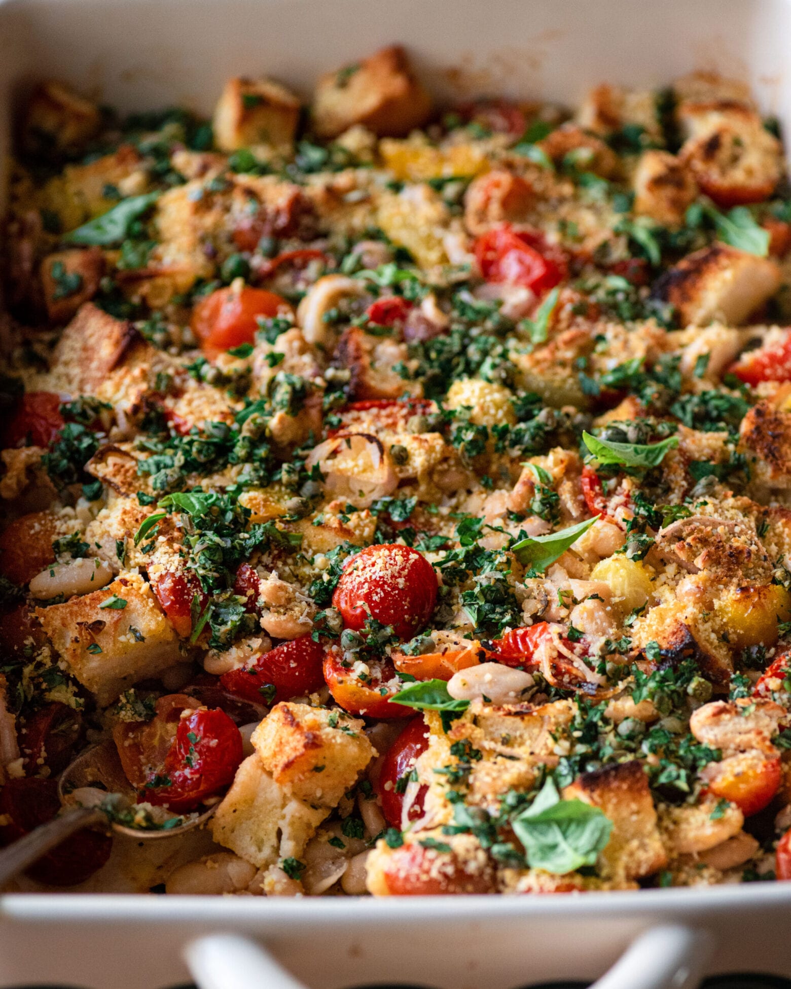closeup of tomato and white bean casserole with fresh basil